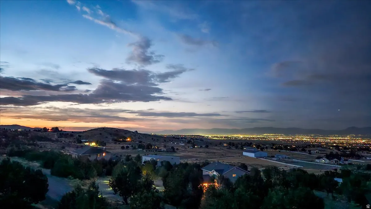 Expansive landscape featuring distant city lights under a twilight sky