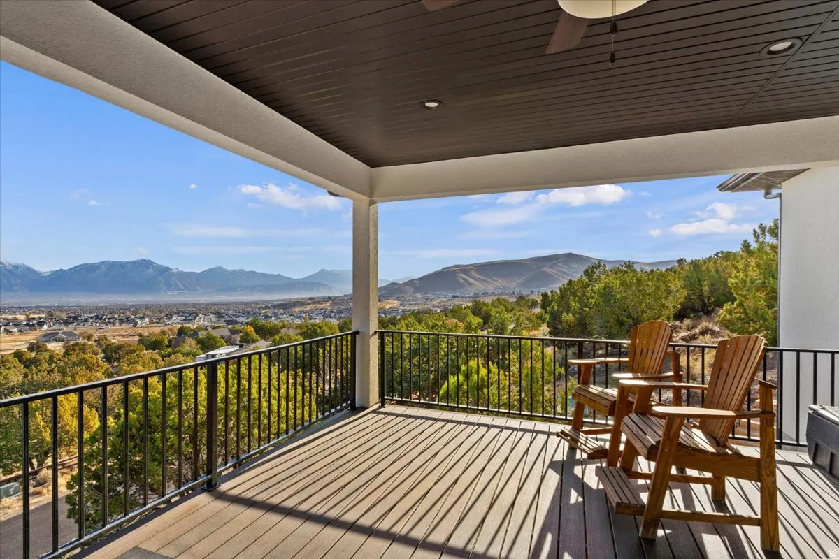 Covered deck with wood-finish flooring and black metal railing