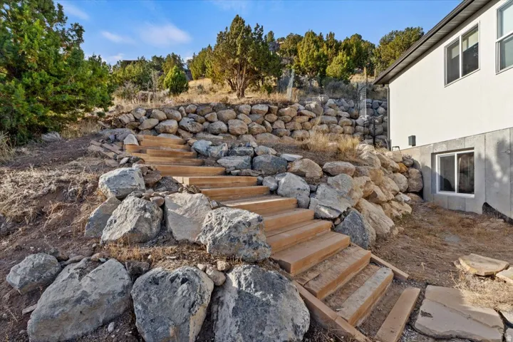 Terraced landscaping with natural rock retaining walls and wood steps