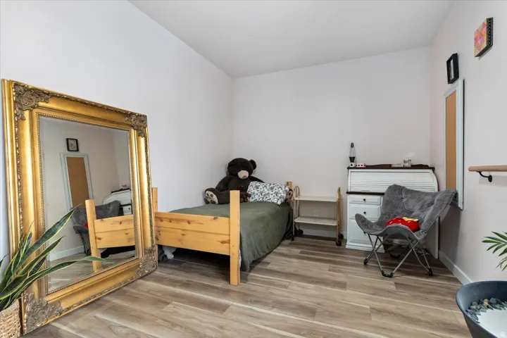 Spacious room featuring wood-finish flooring and light-toned walls