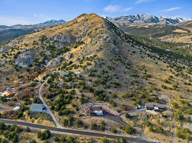 Property situated on a sloped, natural landscape with a prominent mountain backdrop
