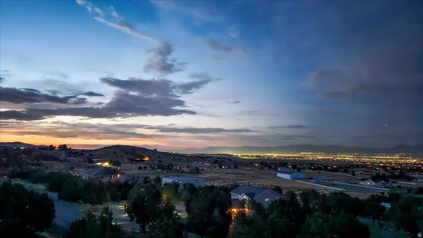 Expansive landscape featuring distant city lights under a twilight sky