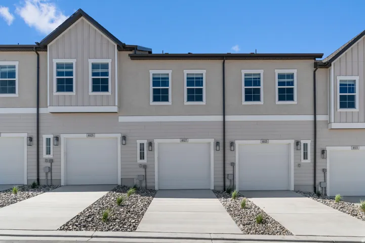 Contemporary townhome exterior featuring stucco and vertical siding accents