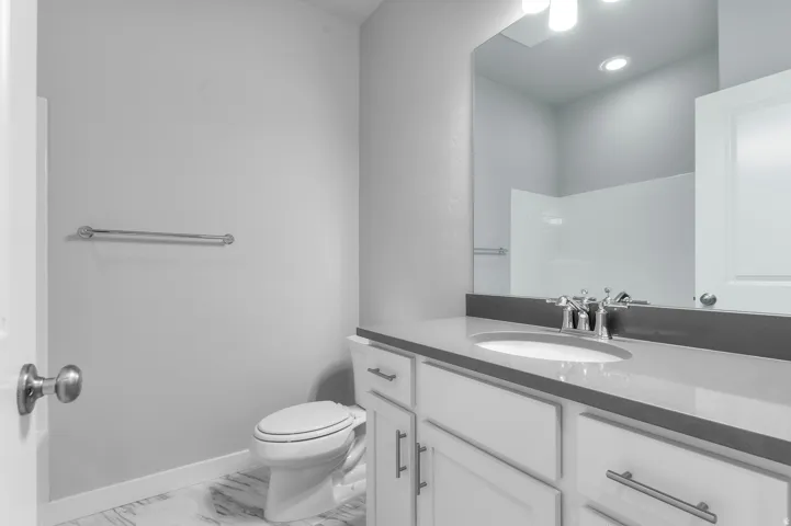 Vanity with a light-colored countertop, undermount sink, and chrome fixtures