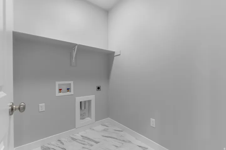 Laundry area featuring a built-in shelf, plumbing hookups, electrical outlet, and tile flooring