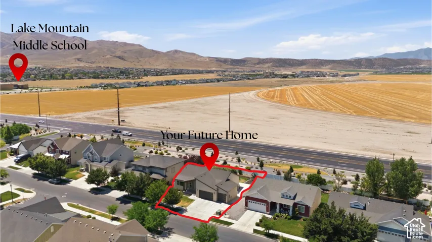 Aerial perspective showcasing a residential property with an attached garage and a concrete driveway