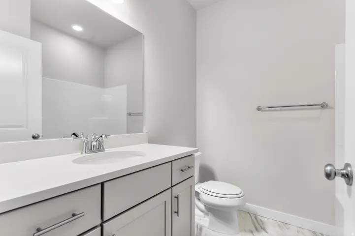 Spacious vanity with light-toned cabinetry, a polished chrome faucet, and integrated sink