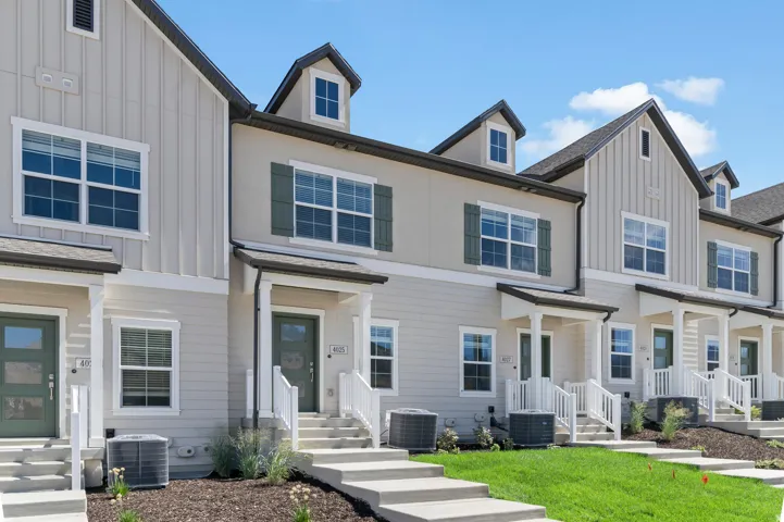 Contemporary townhome exteriors featuring dormer windows, board and batten accents, and covered entryways