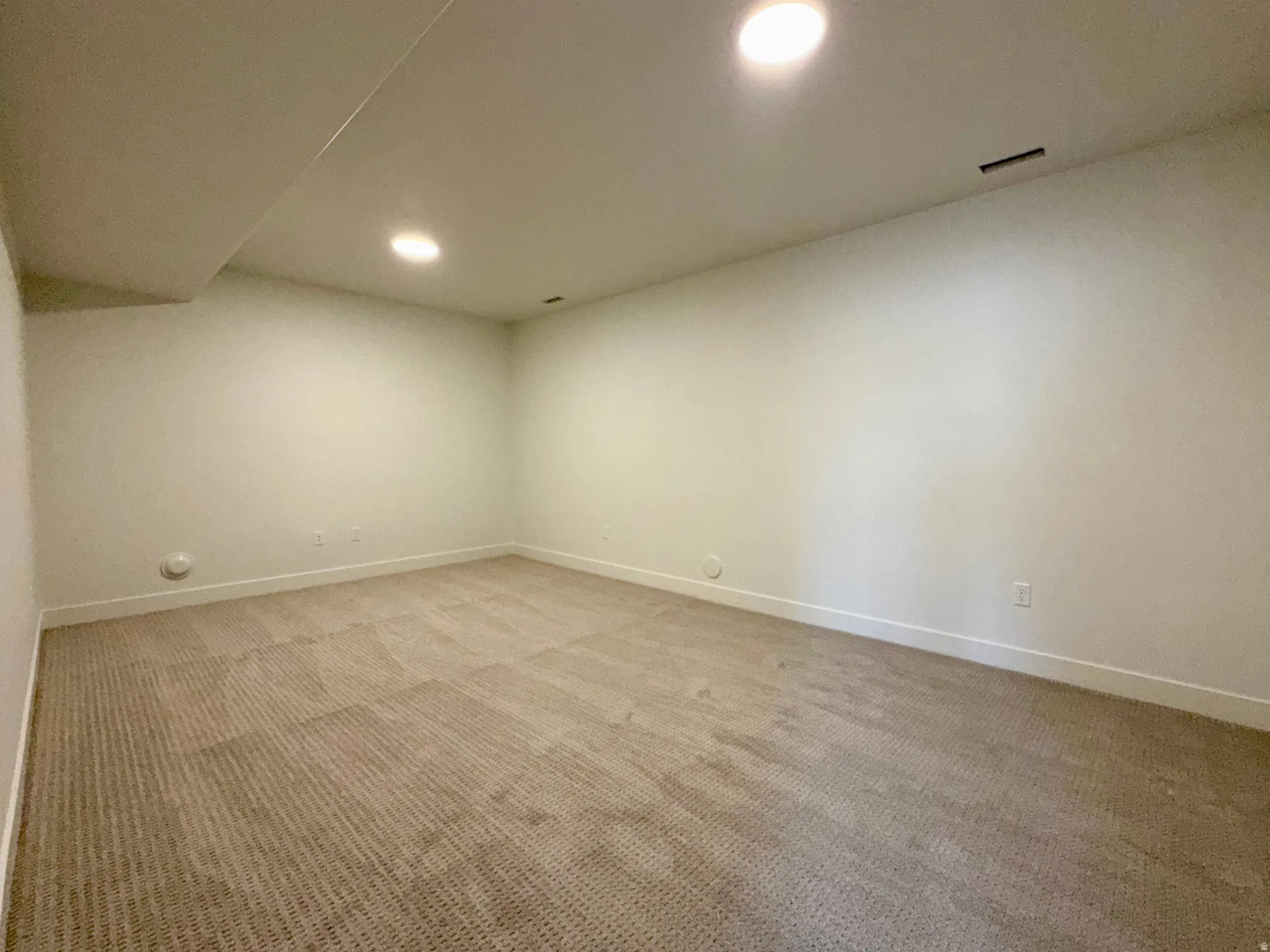 Neutral-toned wall-to-wall carpeting complements light-colored walls and baseboards