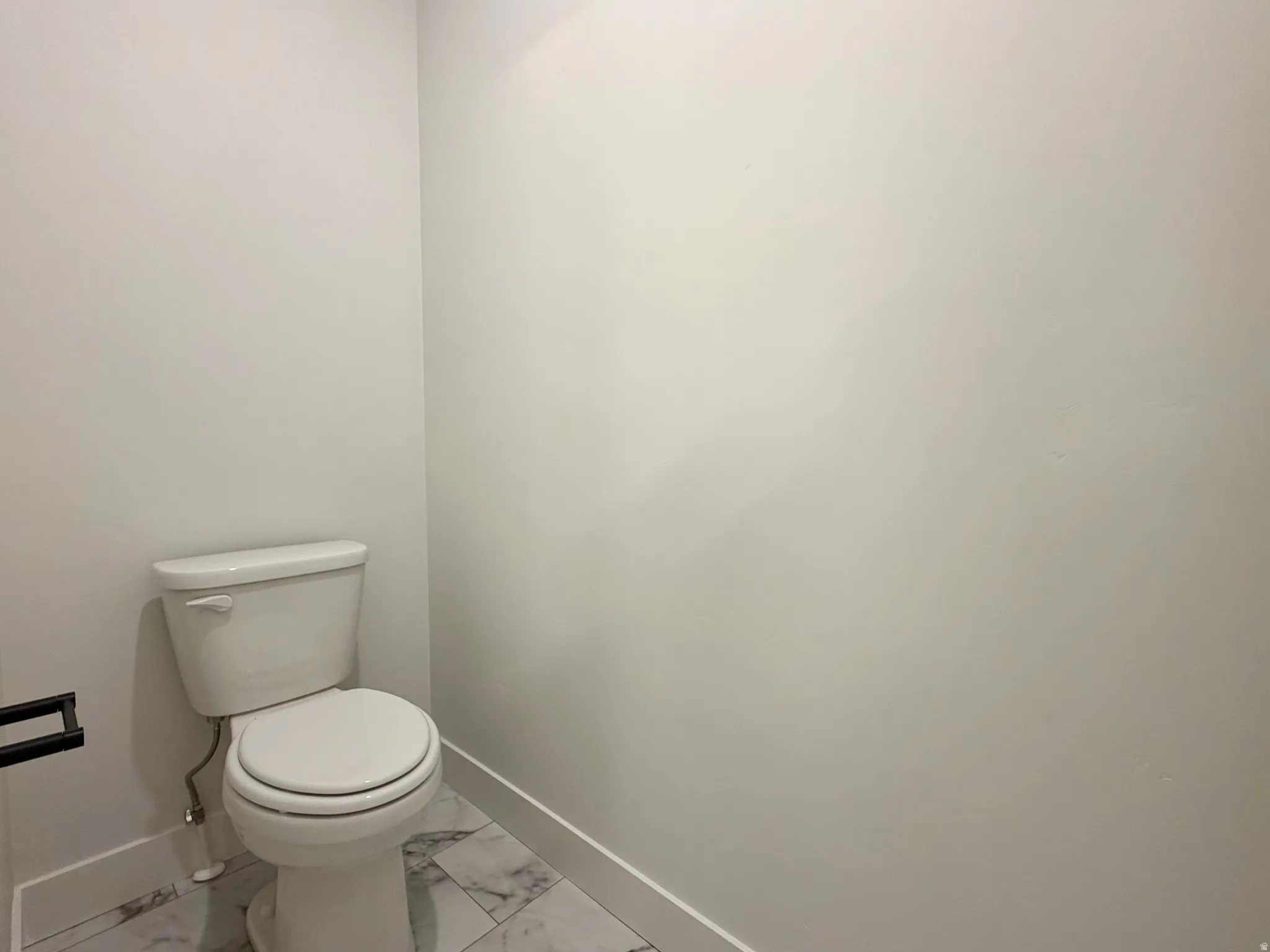 White toilet with a round bowl and lever flush