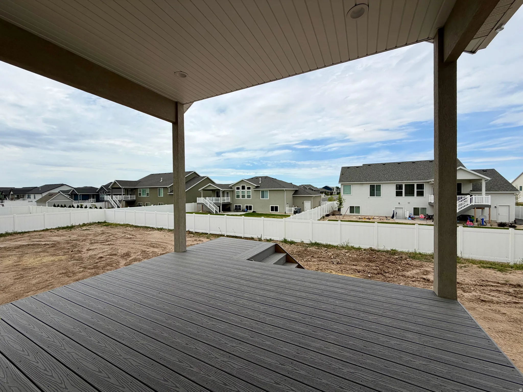 Spacious covered deck featuring composite decking and integrated steps