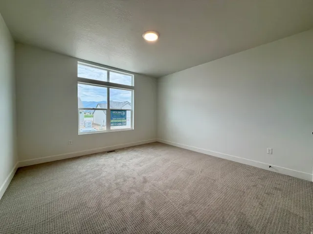 Carpeted room with a large multi-pane window and transom