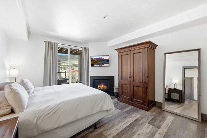 Interior space featuring wood-finish flooring, a built-in fireplace, and a sliding glass door providing outdoor access