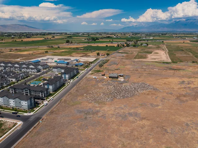 Expansive undeveloped land featuring a single-story structure and distant mountain ranges