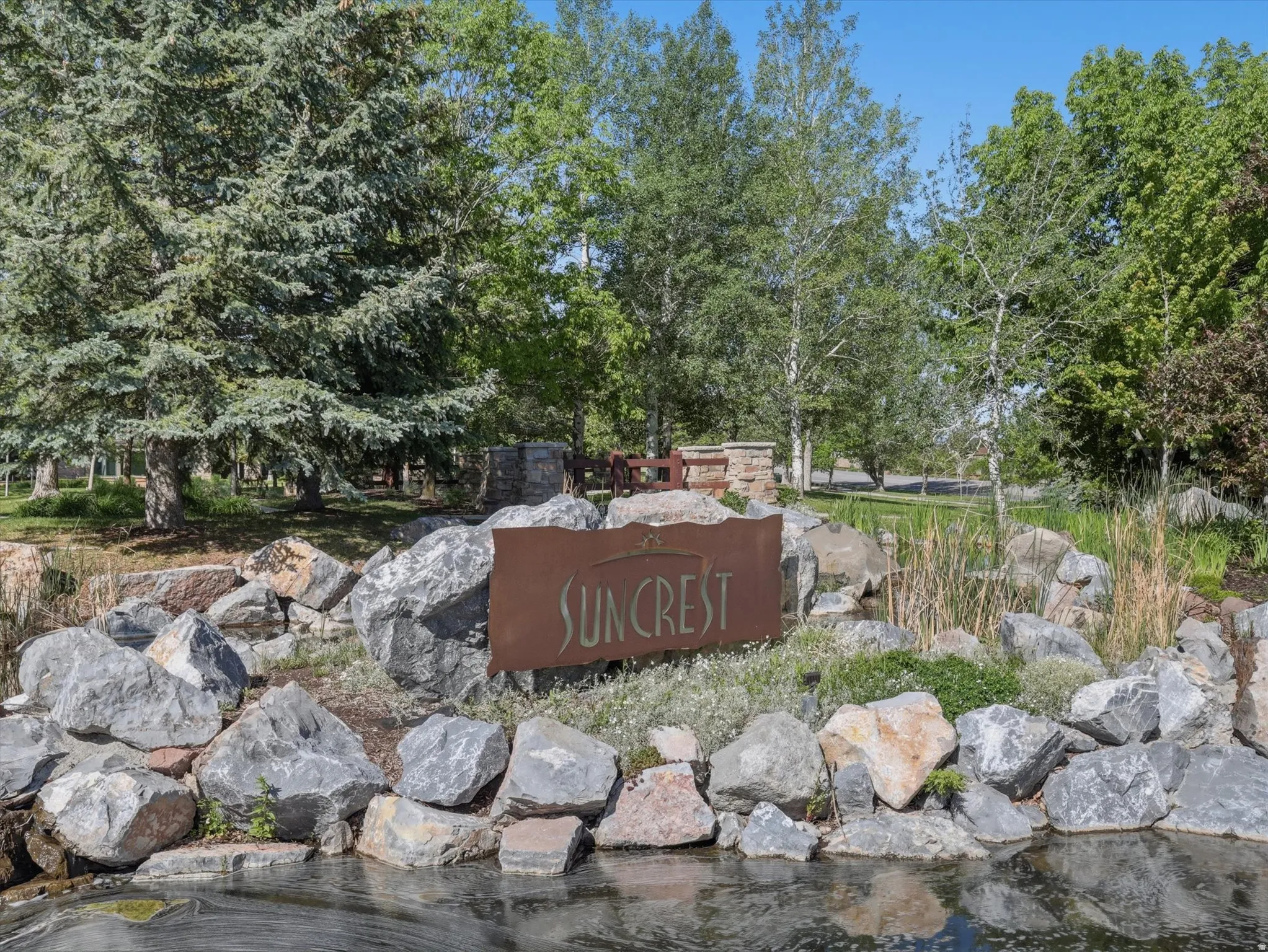 Entryway sign framed by natural stone landscaping