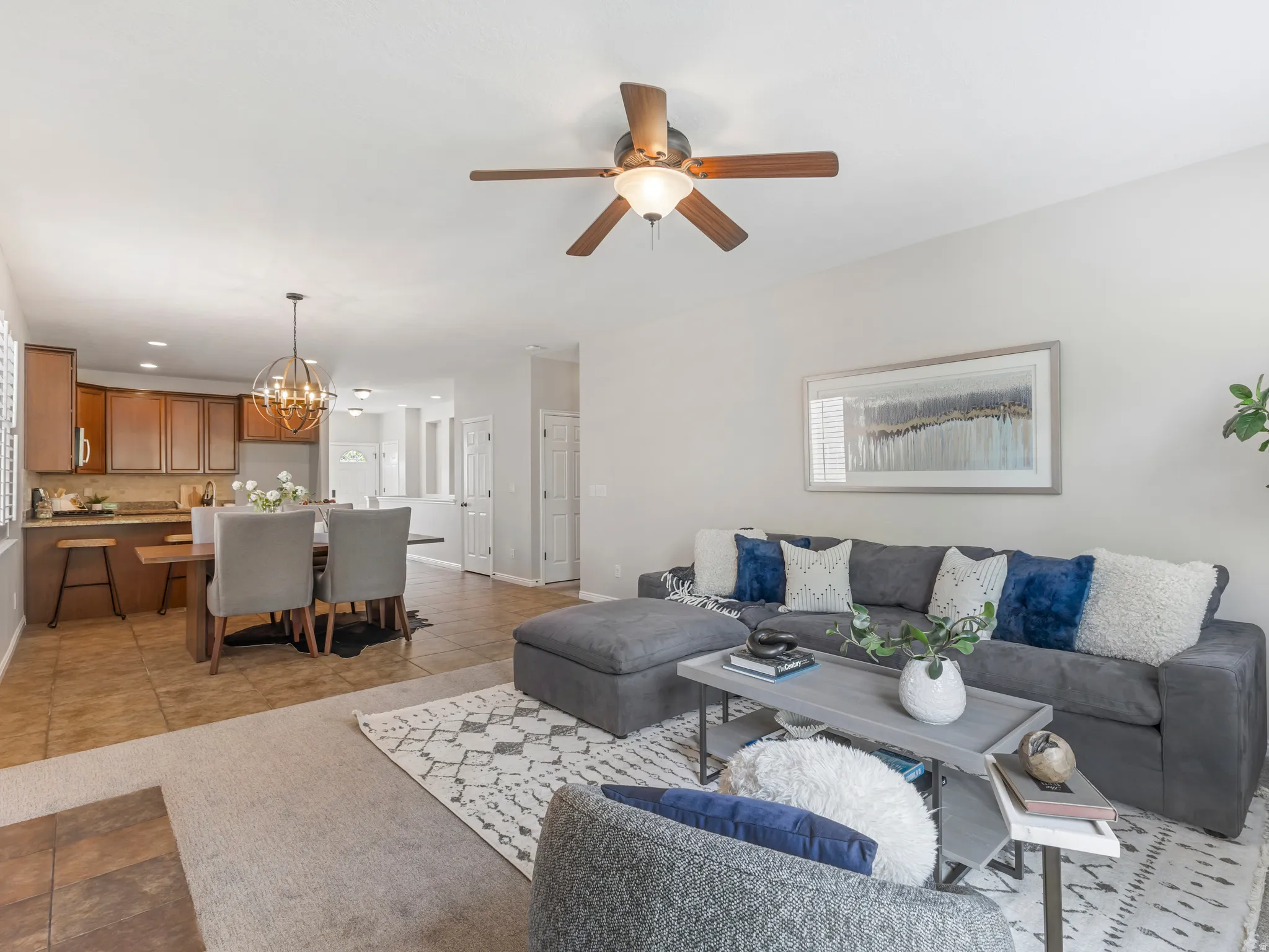 Open concept living area featuring a ceiling fan, recessed lighting, and tile flooring