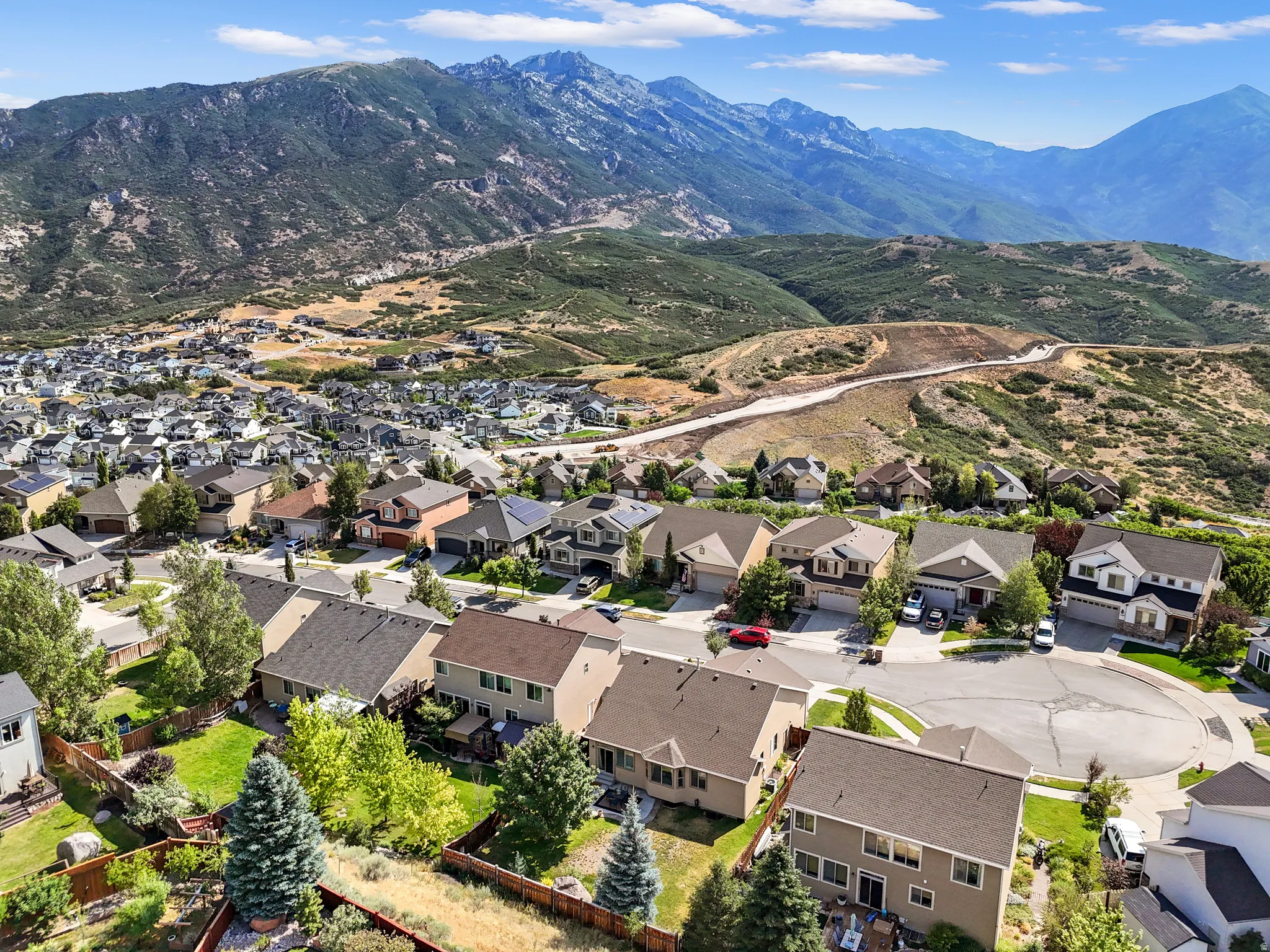 Residential neighborhood featuring established homes, paved streets, and a mountainous backdrop