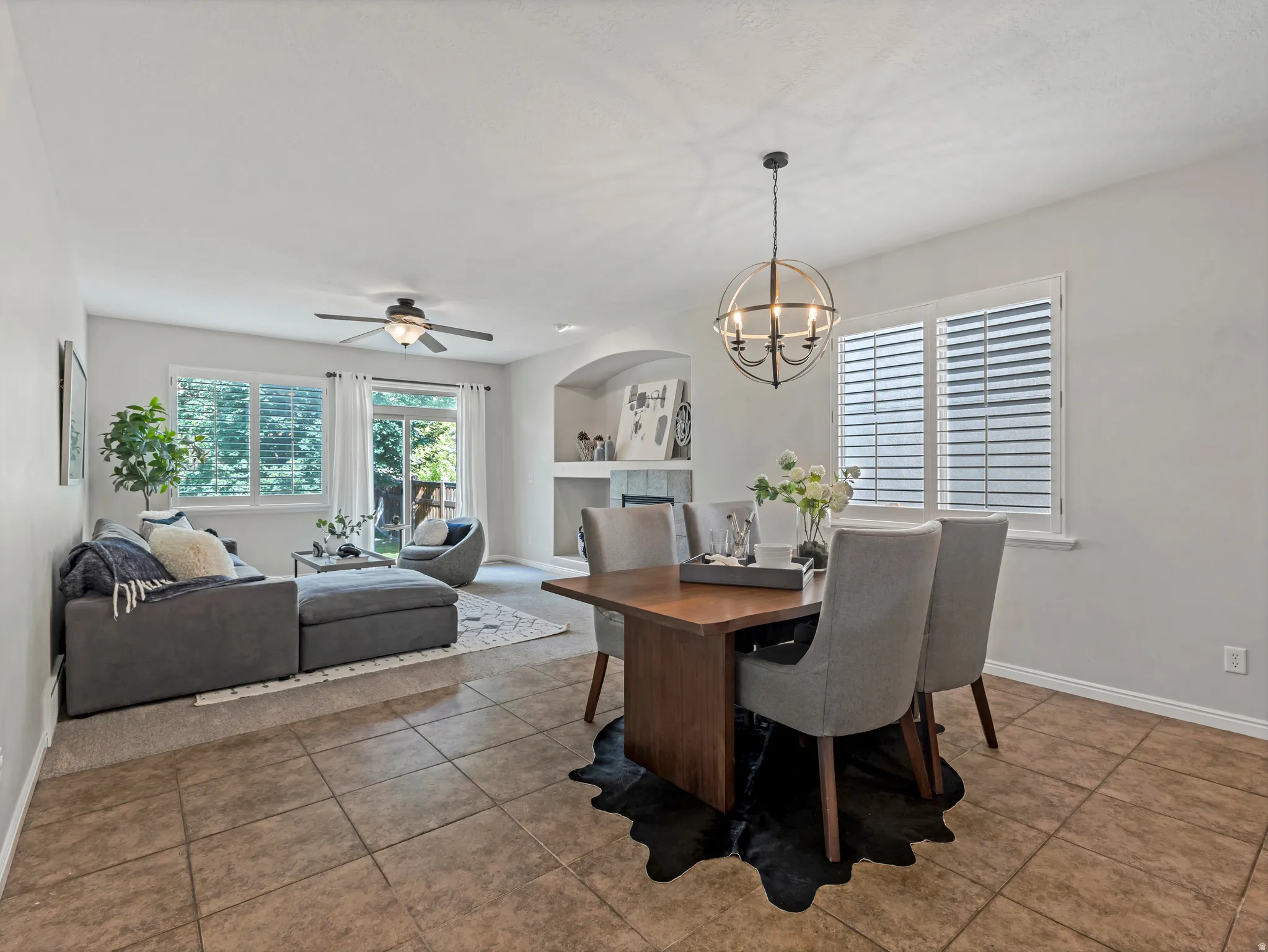 Dining area featuring a wood-finish table, upholstered chairs, and a spherical chandelier