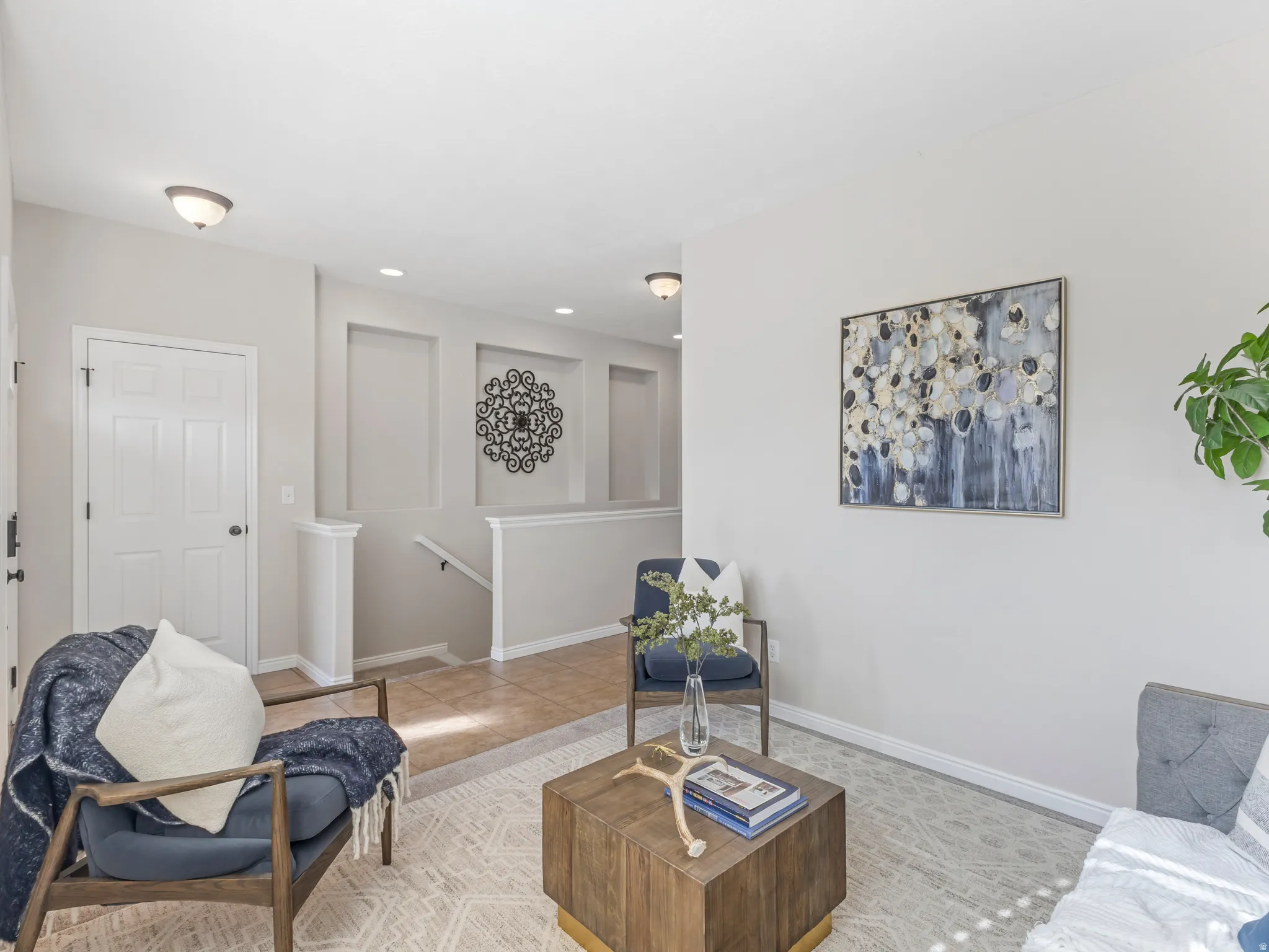 Living area featuring light neutral wall paint, recessed wall niches, and a white paneled door