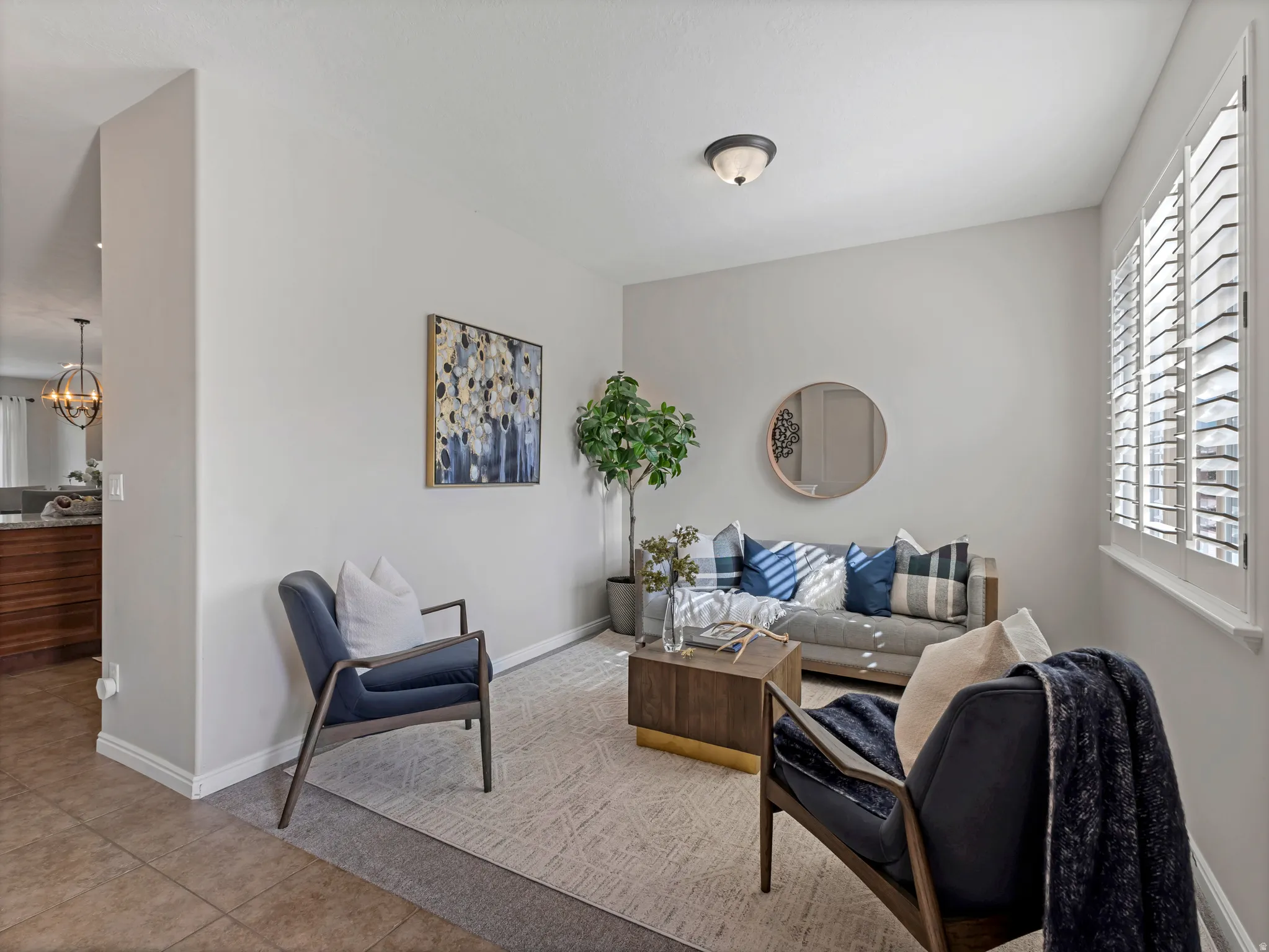 Living area featuring neutral wall tones, plantation shutters, and recessed lighting