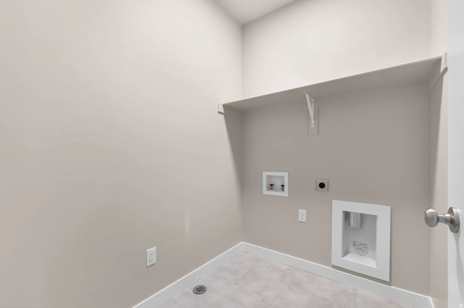 Laundry area featuring a built-in shelf, neutral wall tones, and tiled flooring