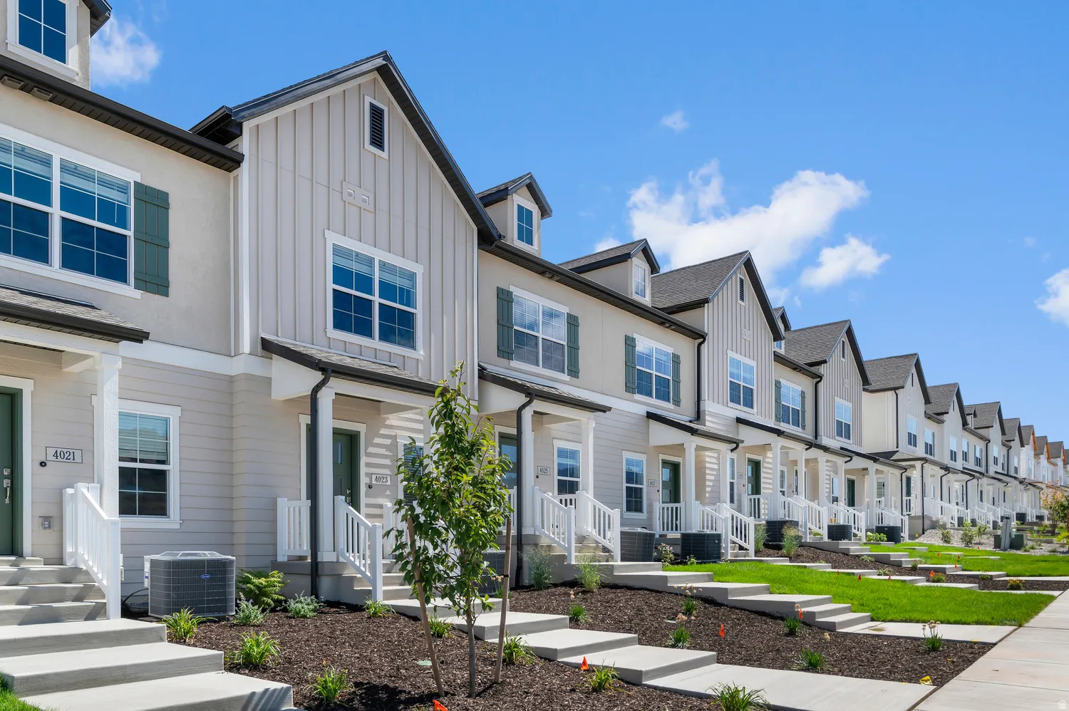 Row of multi-level properties with gabled roofs, horizontal siding, and board-and-batten accents