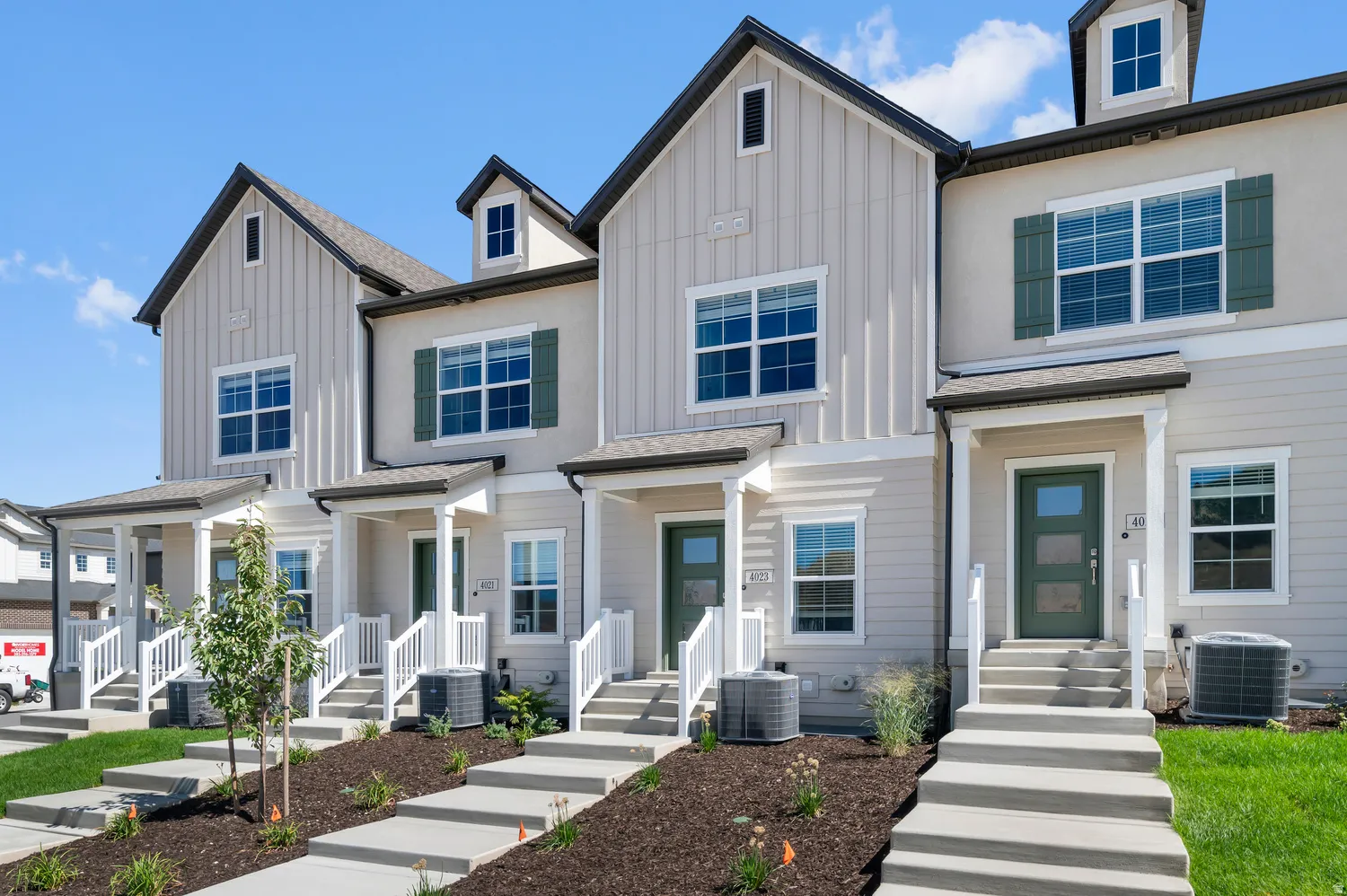 Contemporary townhome exterior with board and batten siding, multiple pane windows, and a covered porch entry