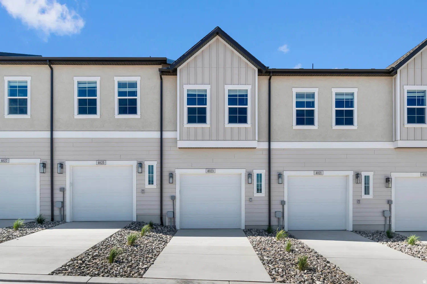 Modern townhome exterior featuring clean architectural lines, attached garages, and a combination of stucco and siding finishes