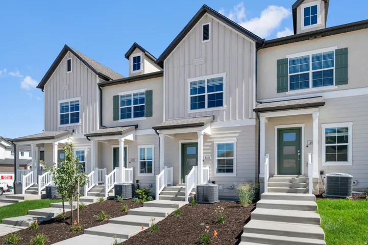 Contemporary townhome exterior with board and batten siding, multiple pane windows, and a covered porch entry