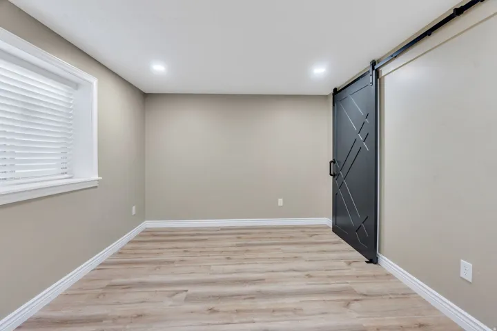 Room featuring a prominent black barn door with geometric detailing
