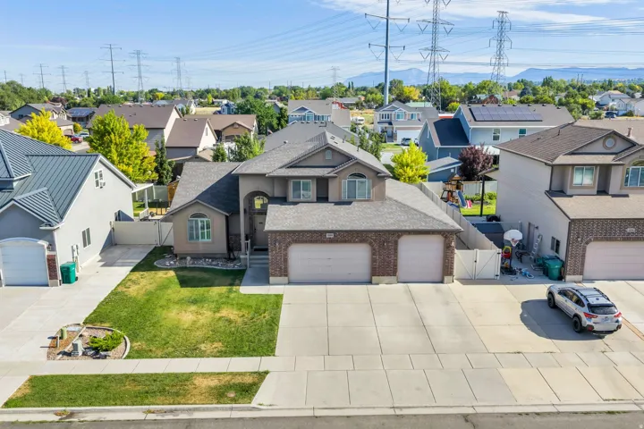 Two-story residence featuring a brick and stucco facade, a two-car garage, an arched entry, and a paved driveway