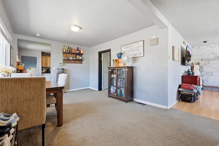 Carpeted dining area with light grey walls and white baseboards