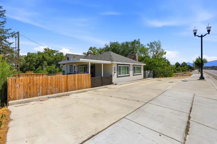 Single-story residence featuring a covered porch entry, multi-pane windows, and a paved front area