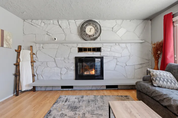 Stone-clad fireplace with a raised hearth, integrated mantel, and a black firebox