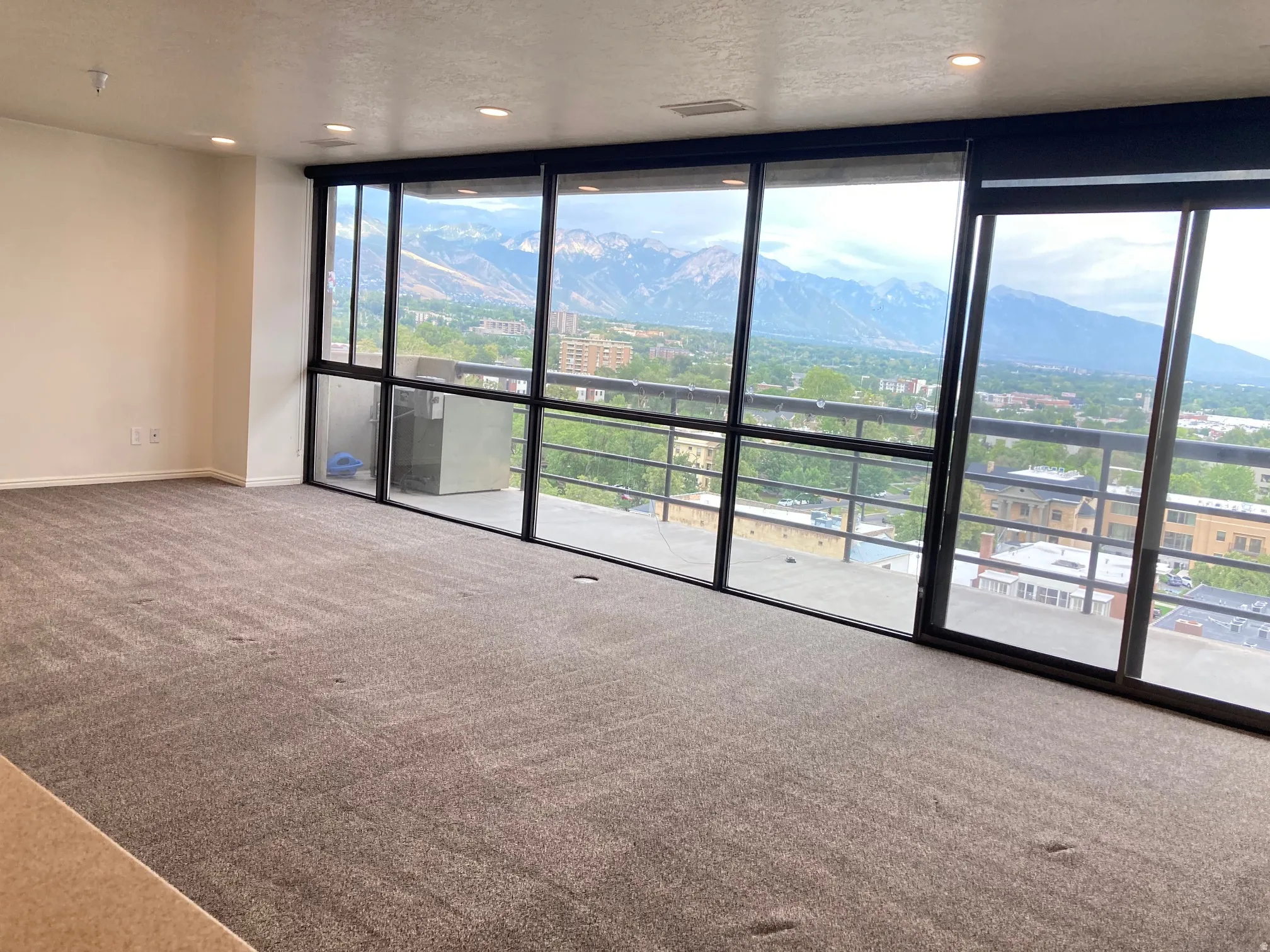 Floor-to-ceiling windows with mountain and city scenery
