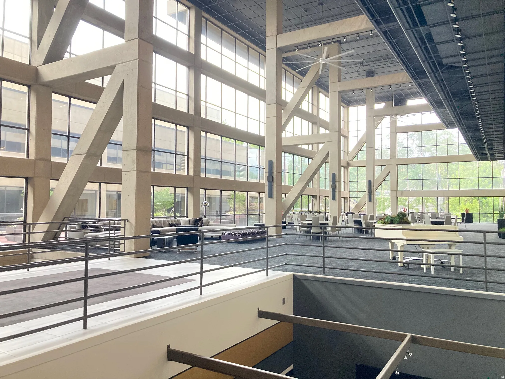 Dramatic atrium space featuring extensive multi-story window walls and exposed concrete structural beams