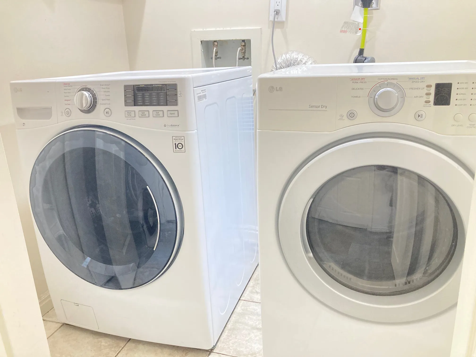 Dedicated laundry area featuring a front-loading washer and dryer set, neutral wall color, and tiled flooring