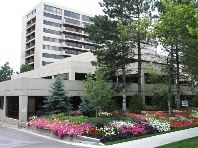Multi-story building featuring a facade of light-colored panels and dark-framed windows