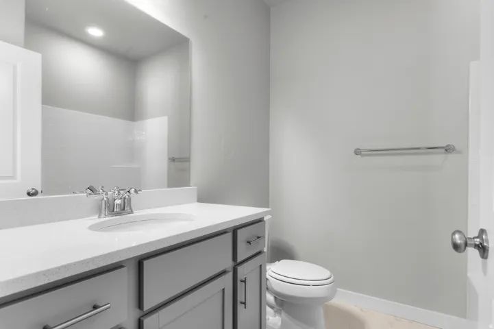 Vanity with a white countertop and undermount sink, chrome faucet, and gray shaker-style cabinetry with chrome hardware