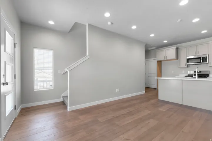Wood-finish flooring, recessed lighting, and light gray wall tones
