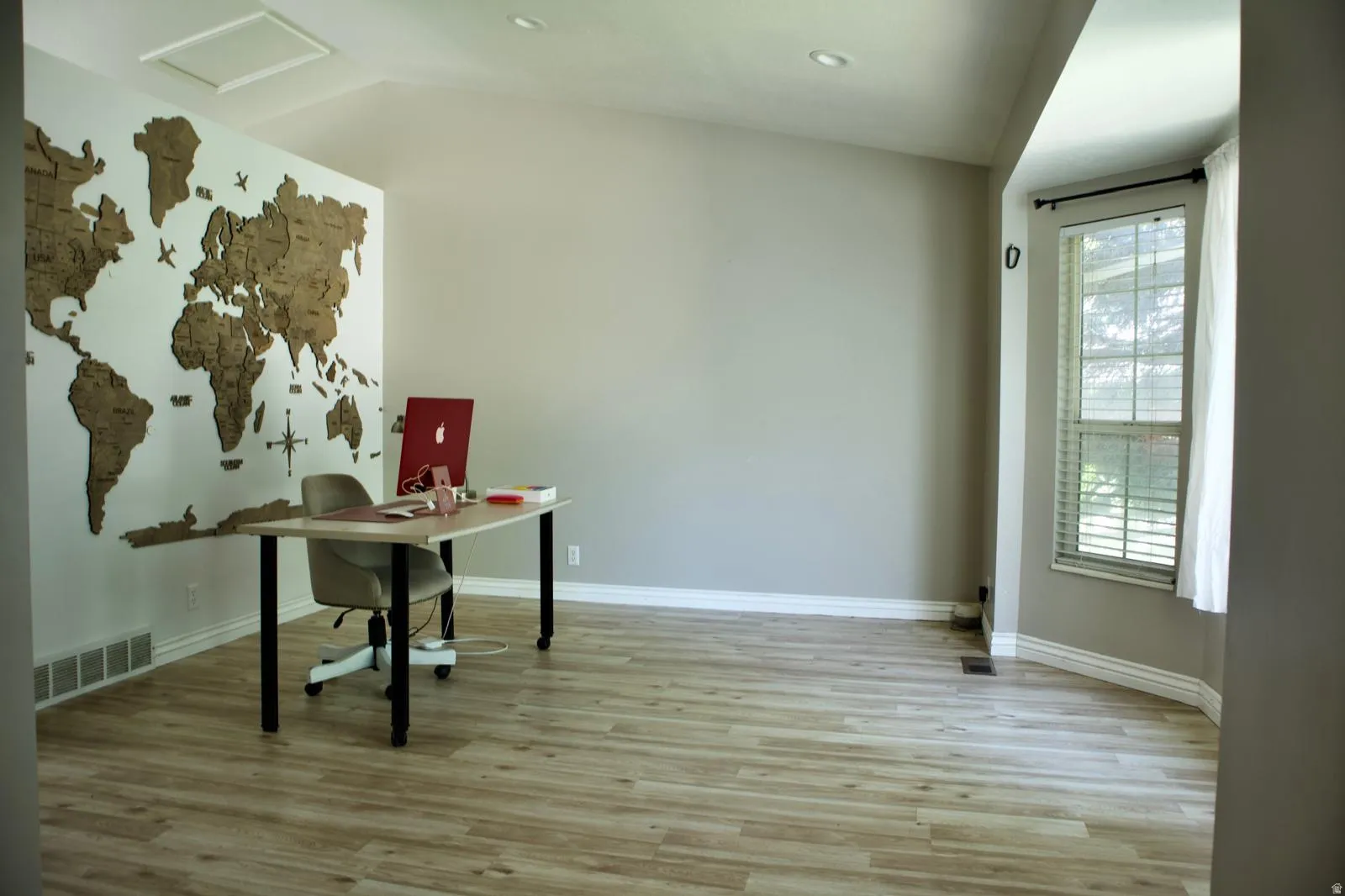 Bright room featuring wood-finish flooring, a vaulted ceiling, recessed lighting, and a bay window