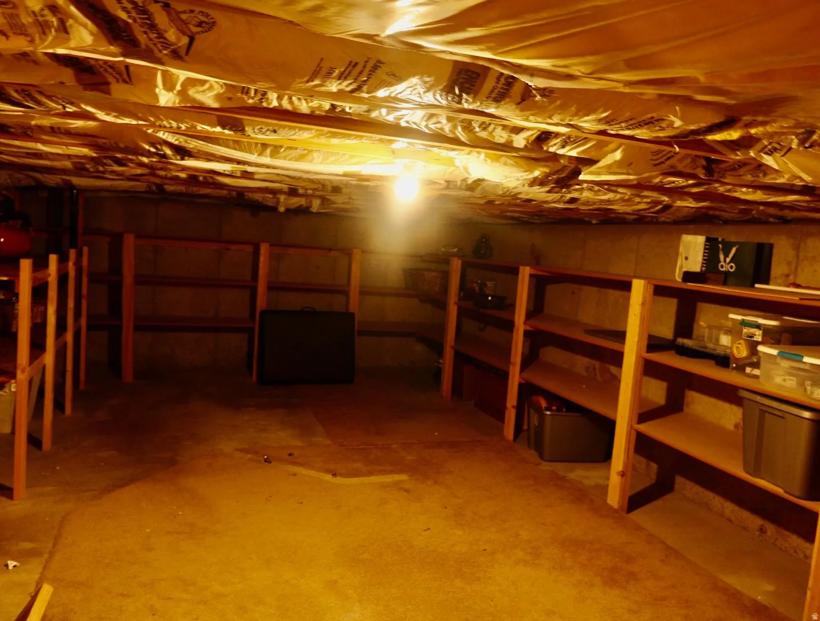 Unfinished basement with concrete flooring and exposed ceiling insulation