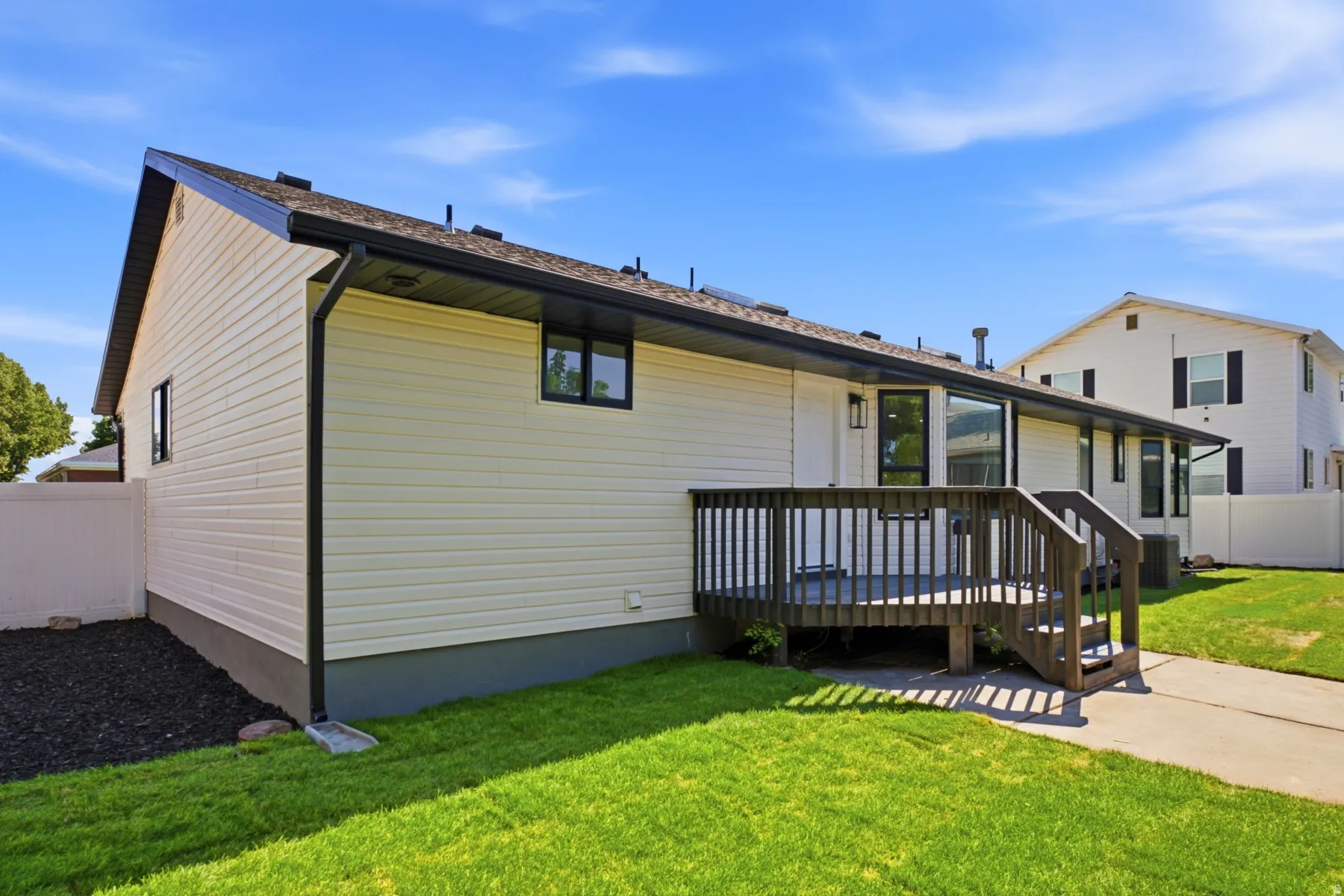 Exterior featuring light-colored siding, dark-trimmed windows, and a dark roof