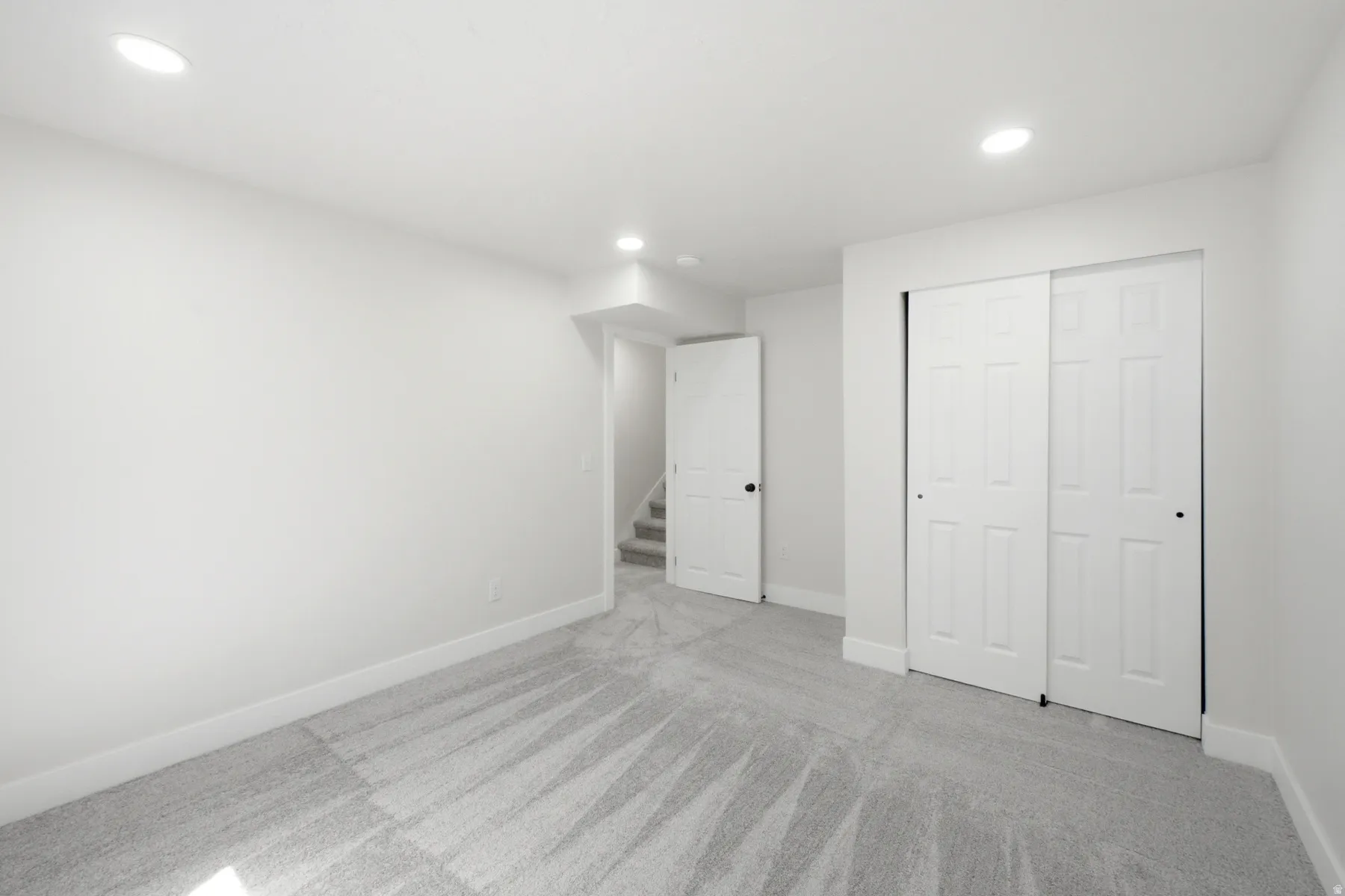 Bright interior room featuring light gray carpet flooring and white walls