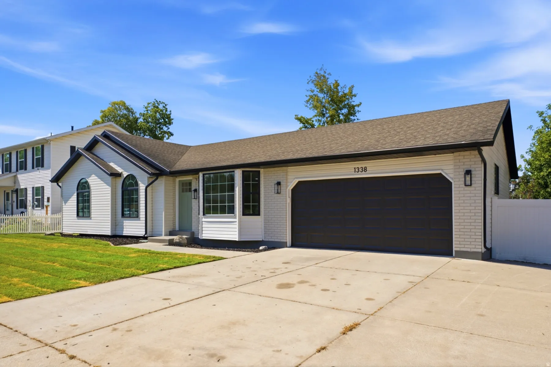 Contemporary exterior featuring white siding and brick accents