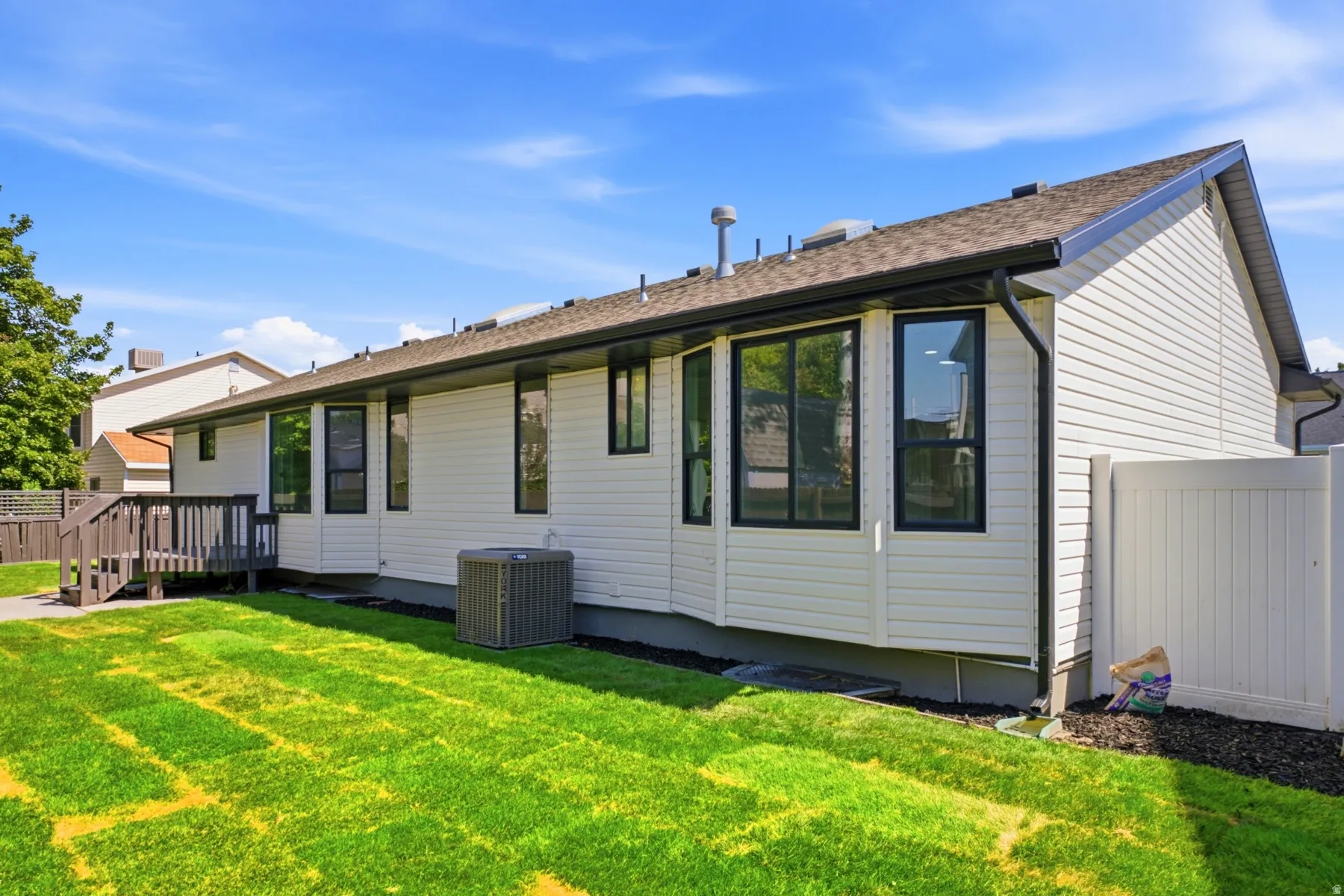 White horizontal siding exterior with a brown shingle roof and black gutters