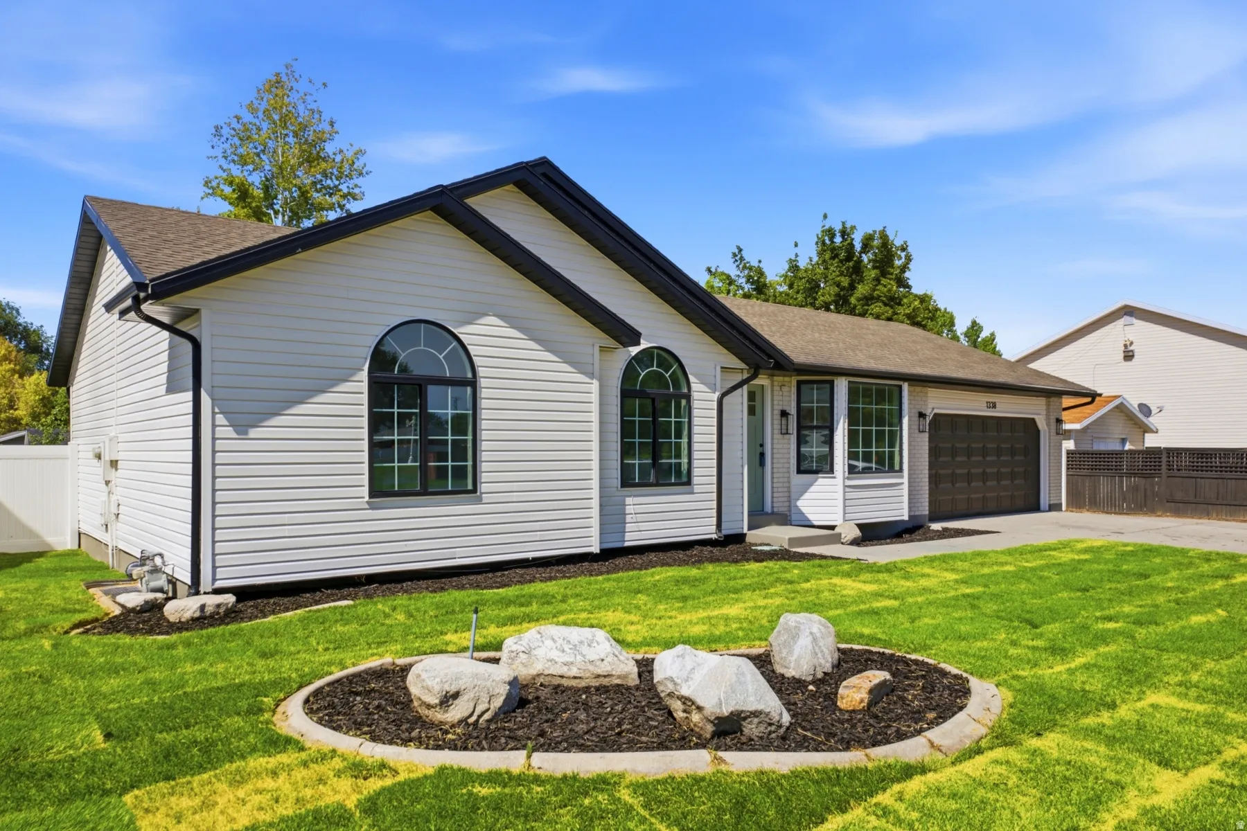 Contemporary single-story residence featuring white siding and black trim