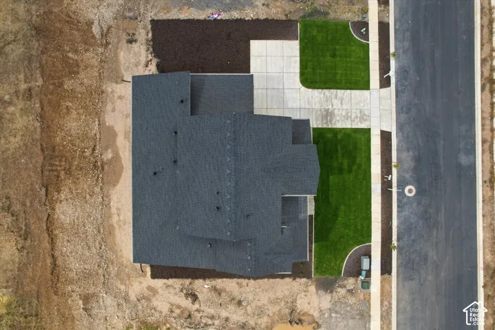 Aerial view featuring a multi-gabled roof, concrete paved walkway, and landscaped lawn sections