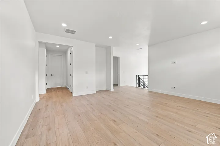 Interior space featuring wood-finish flooring, recessed lighting, and a metal stair railing