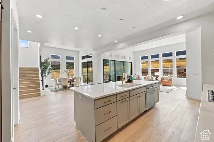 Open floor plan featuring wood-finish flooring, recessed lighting, and a large central island with quartz countertops